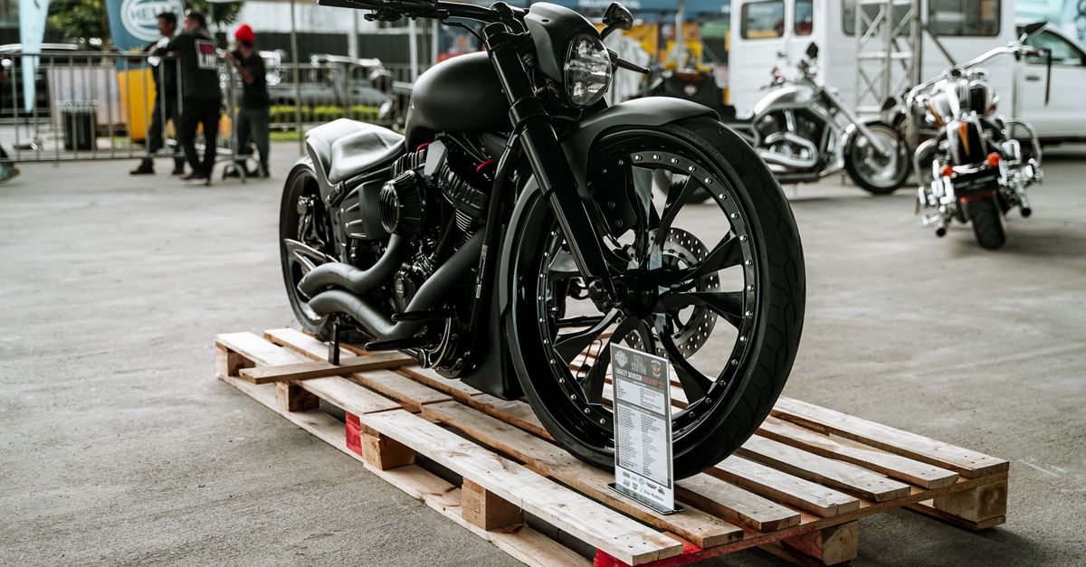 A stylish black motorcycle showcased on a wooden pallet in an outdoor event in Quezon City, Philippines.