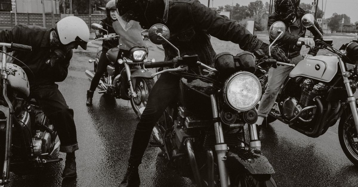 Group of motorcyclists riding on a wet street showcasing dynamic and adventurous vibe.